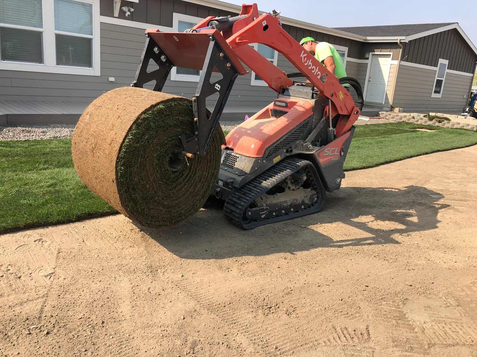 Big roll getting installed on mini skid steer